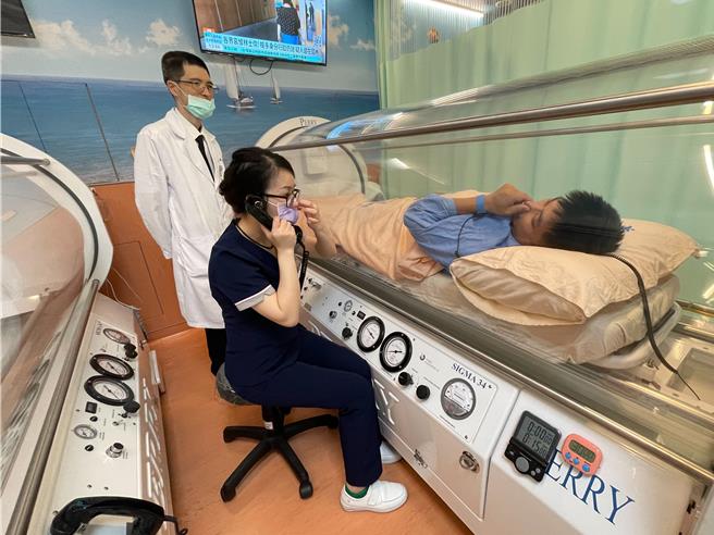 部苗骨科医师汪家成（左）亲视高压氧治疗病人，适时给予关心。（部立苗栗医院提供／谢明俊苗栗传真）