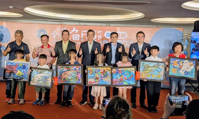 基隆区渔会承办今年全国渔民节系列活动，3日上午记者会中，由渔业署代理署长王正芳（后排左4）为全国渔民节系列活动之一的大渔旗着色比赛得奖者颁奖。（张志康摄）