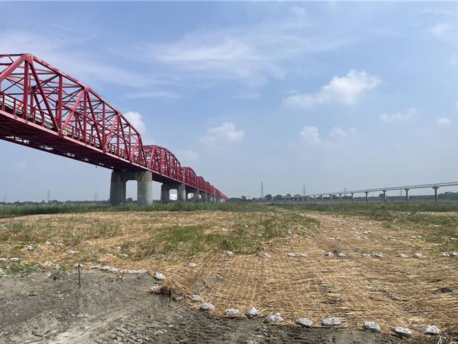 第四河川署在西螺大桥下的浊水溪河床裸露地铺设草席抑制，并促使种子湿润发芽。（周丽兰摄）