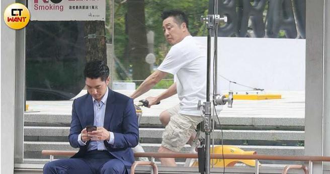 拍摄剧情看似哈林在骑车时，遇上坐在公车站候车亭的蒋万安。（图／本刊摄影组）