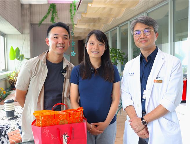 香港31岁的梁姓女子（中）在先生的陪同下，来到新竹马偕接受达文西机械手臂手术，摘除纵膈腔的巨型肿瘤，术后4天即康復出院。主治医师胸腔外科主任陈百玺（右）特地送上新竹名产。（新竹马偕提供／王惠慧新竹传真）