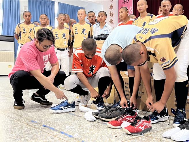 南投縣議員簡千翔幫孩子們換上新球鞋，球員們非常感動。（楊靜茹攝）