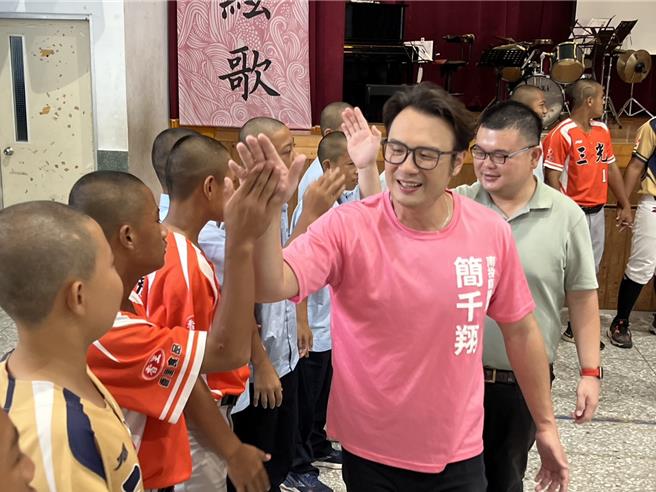 南投縣議員簡千翔與豐營工業公司董事長特助簡佑庭與三光國中棒球隊球員擊掌，勉勵他們比賽成績更上一層樓。（楊靜茹攝）
