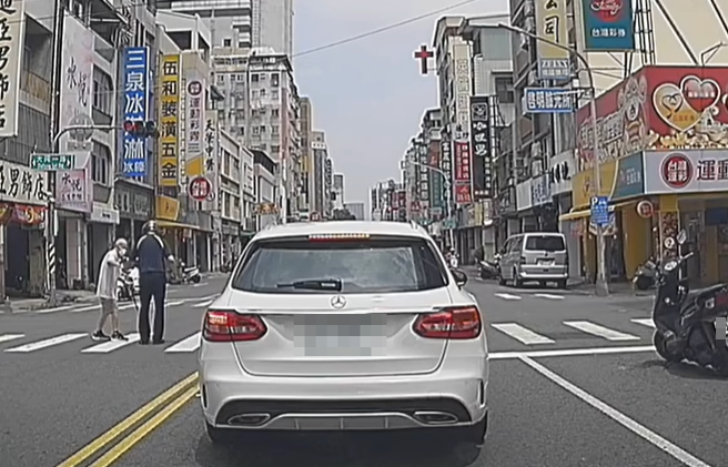 高雄有騎士因看到拐杖伯腳步蹣跚來不及通過路口，便趕緊上前攙扶通過。（圖／翻攝自臉書爆廢公社）