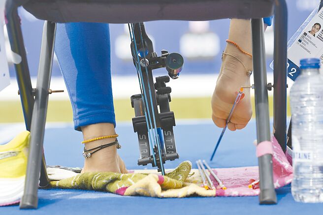 罹患海豹肢症的人，四肢会像海豹般短小，尤其常表现在上肢。图为巴黎帕运复合弓混双铜牌西塔戴薇比赛时用右脚食、拇指夹起放在地上的箭支。（美联社）