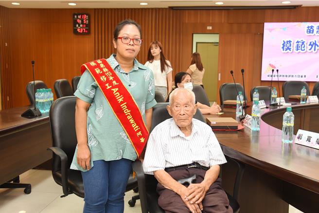 苗栗縣政府5日頒獎表揚優良模範移工，印尼家庭類看護工阿蒂細心照顧99歲的阿公郭火炎，主雇培養厚情誼。（苗栗縣政府提供／謝明俊苗栗傳真）