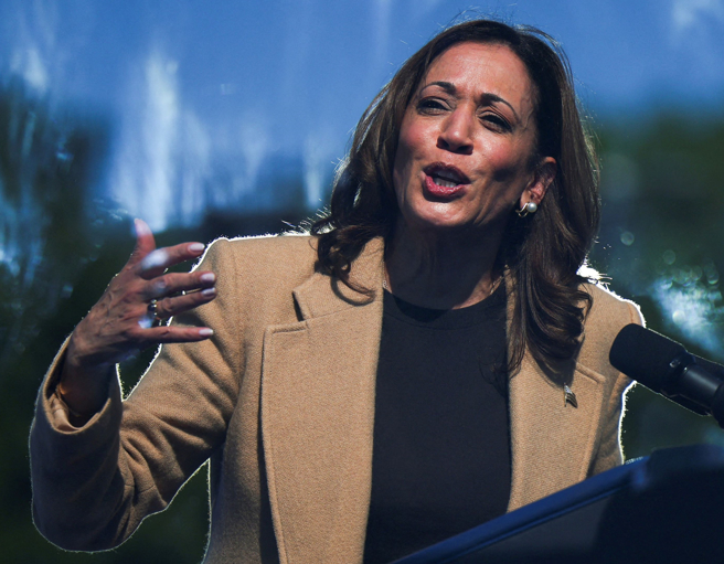 美國民主黨總統候選人賀錦麗4日在新罕布夏北漢普頓（North Hampton）造勢集會中，透過防護玻璃，向群眾發表談話的神情。（路透）