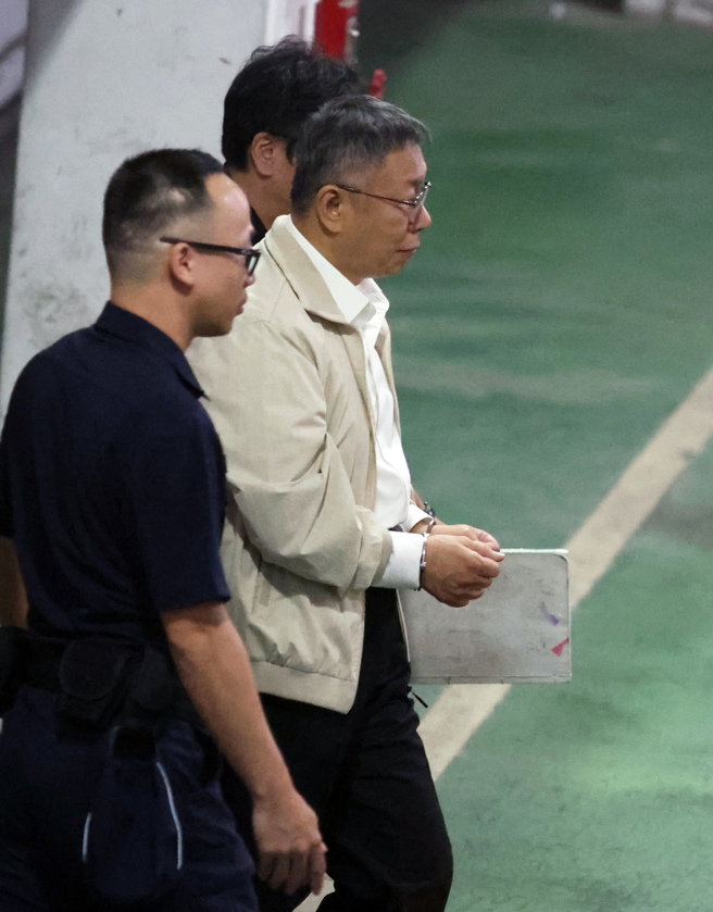 京华城案，台北地方法院5日重开羁押庭，裁定前台北市长、民眾党主席柯文哲（中）羁押禁见，柯戴手铐在法警的陪同下走向囚车。（姚志平摄）