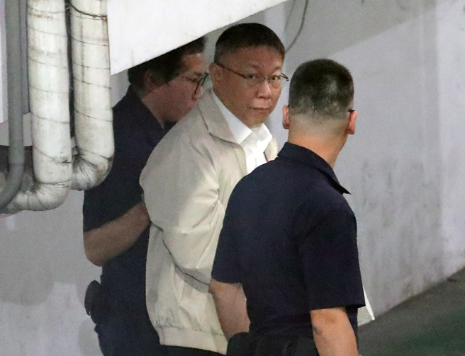 台北地检署侦办京华城案，声押前台北市长柯文哲，台北地方法院裁定无保请回，检察官抗告后，高院发回更裁。台北地方法院5日上午开庭处理程序事项，下午2时正式召开羁押庭，经过2个多小时的讯问，裁定柯文哲羁押禁见。柯文哲（中）约于下午5时50分，被上铐押上囚车，走进囚车道时一度望向大批正在拍摄的媒体记者，接着移送台北看守所。（黄世麒摄）