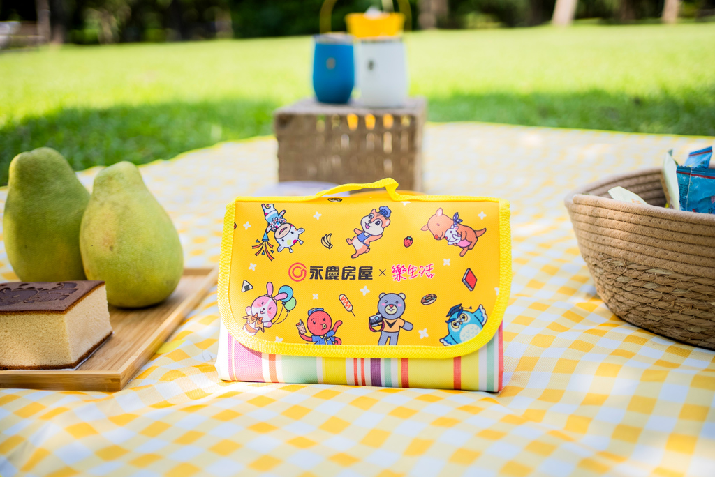 永慶房屋「幸福團圓野餐墊」，提供有黃白格與七彩條紋2種樣式，輕鬆收納整理，還具有防水性，讓大家方便帶出門，大幅提升戶外活動體驗。(圖/永慶房屋提供)