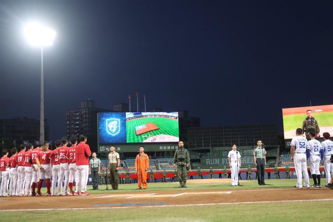  「全力出击」职棒主题赛由陆军21炮指部官兵展护国旗下，全场军民齐声高唱国歌。（记者黄迪明摄）