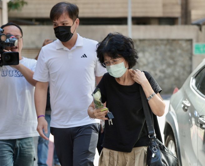 民眾党主席柯文哲卷京华城弊案，遭法院羁押禁见，柯妻子陈佩琪（前）稍早到看守所送生活用品，随后驱车回到北市住处，手持白玫瑰不发一语进入家门。（郭吉铨摄）