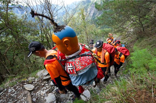 山路崎嶇，神童由隊員們輪流揹。（蕭嘉鴻提供）