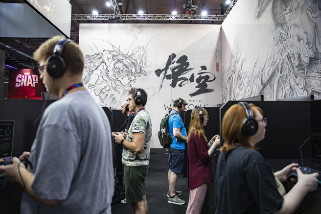 欧美玩家在游戏展上的游戏科学摊位试玩游戏。（图／新华社）