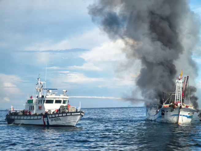 贡寮外海渔船大火，海巡艇立刻前往喷水灭火。(渔民提供)