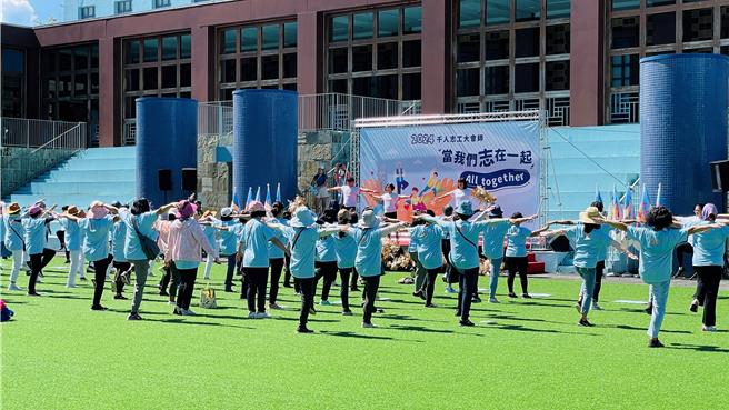 瑜珈老师声声呼唤志工「用热情抵抗艳阳日」，部分志工戴帽下场做瑜珈。（萧嘉蕙摄）