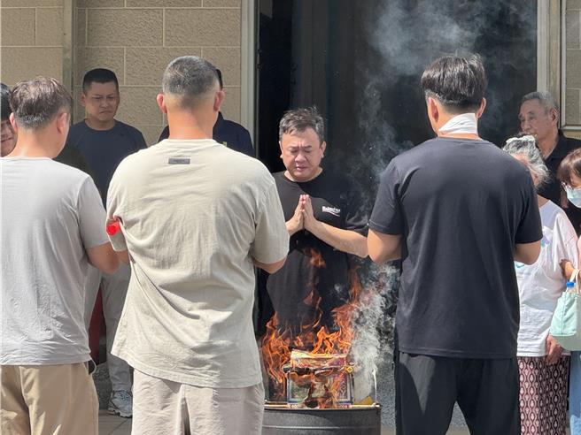 吴健保儿子吴禹寰（中间黑衣者）下午在住家举行「魂轿仪式」召唤父亲大名。（曹婷婷摄）