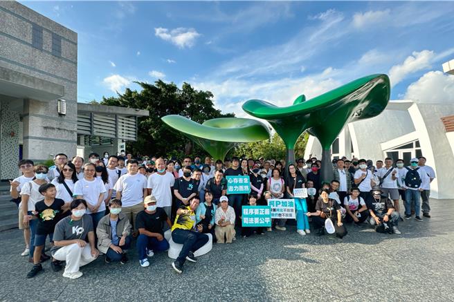 台湾民眾党台南市党部支持者包车北上，中途在中坜休息站一起举标语合影，党部主委林乃立（前排站立黑衣蓝长裤者）呼吁支持者踊跃声援党主席柯文哲。（民眾党台南市党部提供／程炳璋台南传真）