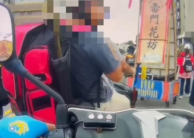 2名男子背著球棒共乘機車，跟在遶境隊伍後，被以為要鬧事，被警方攔下盤查。（警方提供／郭良傑高雄傳真）