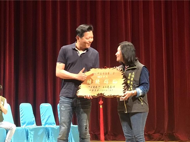 新北市副市长朱惕之颁发「绩优群伦」匾额予三峡区鸢山里里长周文美。（新北市警察局提供）