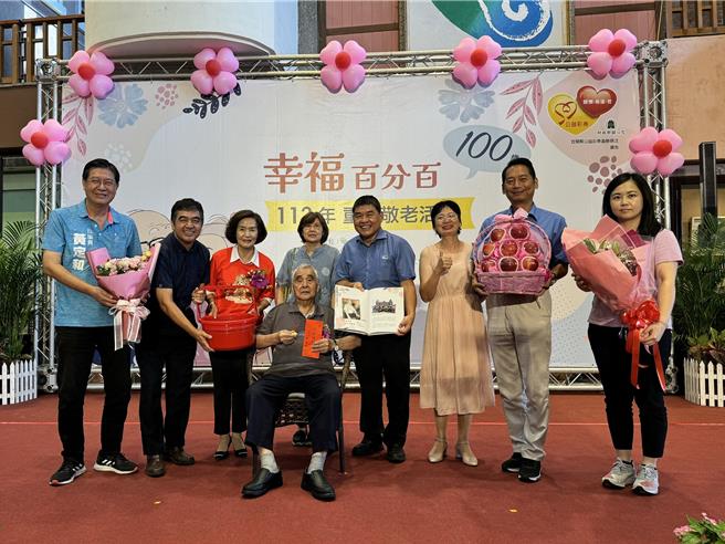 100岁吴增寿阿公（前排中）不停看着手中的红包和金牌，可爱表情逗趣大家。（吴佩蓉摄）