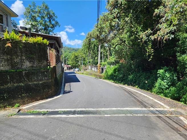 埔里鎮桃米巷一處盲彎，因下坡右側是大排水溝、左側有建築物擋住視線，該路段時常發生車禍。（民眾提供／楊靜茹南投傳真）