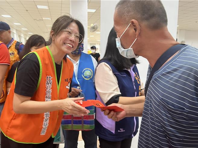 仕招基金會執行長蔡紹云（圖左）發給街友慰問金。（王揚傑攝）