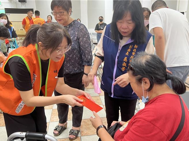 仕招基金會執行長蔡紹云（圖左）發給街友慰問金。（王揚傑攝）