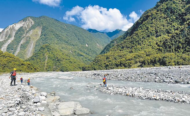 31歲林姓男子8日帶2歲兒子到花蓮縣萬榮鄉青昌溪戲水，回程駕駛吉普車渡過暴漲溪水不慎翻覆，2人遭沖走，林男遺體當晚被尋獲，搜救人員9日清晨在事故地點附近搜找失聯男童。（花蓮縣消防局提供／羅亦晽花蓮傳真）