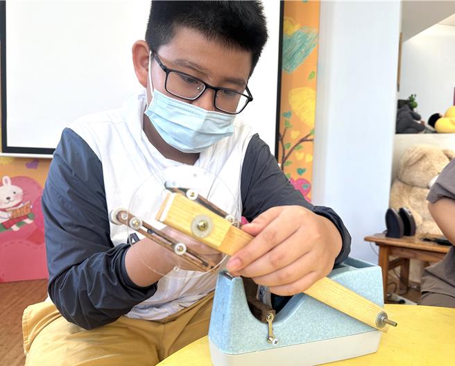 台东丰里国小蝉联达文西国际发明展金牌奖，学生张恩凯使用第一代改造胶带台。（蔡旻妤摄）