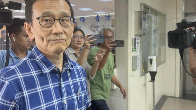 北市府時任副秘書長李得全面對媒體詢問時僅微笑不語。（圖賴佩璇攝）