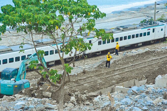 蘇花公路164.5公里崇德段8日因大雨來襲，發生土石流造成鐵公路中斷，經搶修人員搶通鐵路後，台鐵列車慢速通過。（王志偉攝）