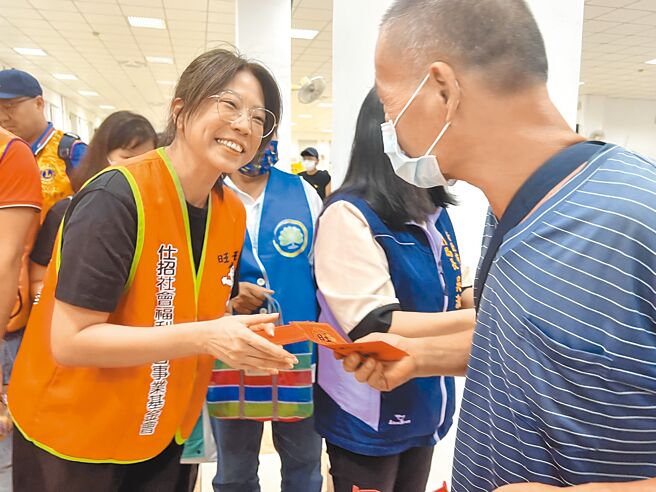 仕招基金會執行長蔡紹云（左）發給街友中秋節慰問金。（王揚傑攝）