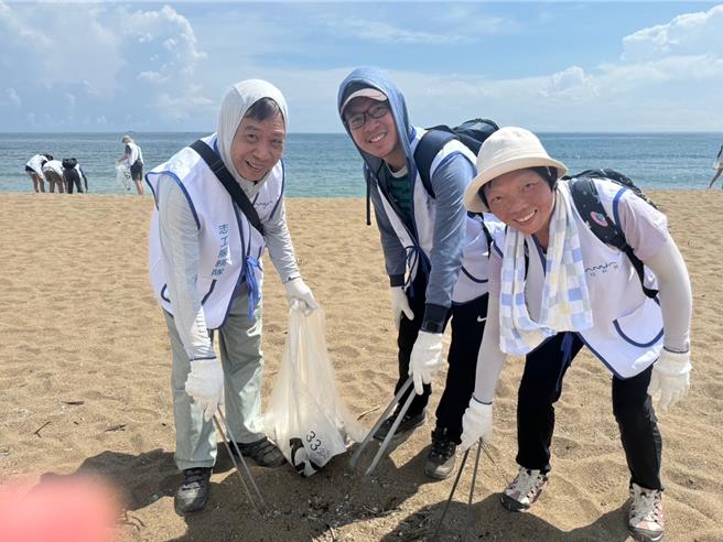 南亞科技企業志工分組進行淨灘，各組齊心協力撿拾枯木和人為垃圾。（新北市社會局提供）