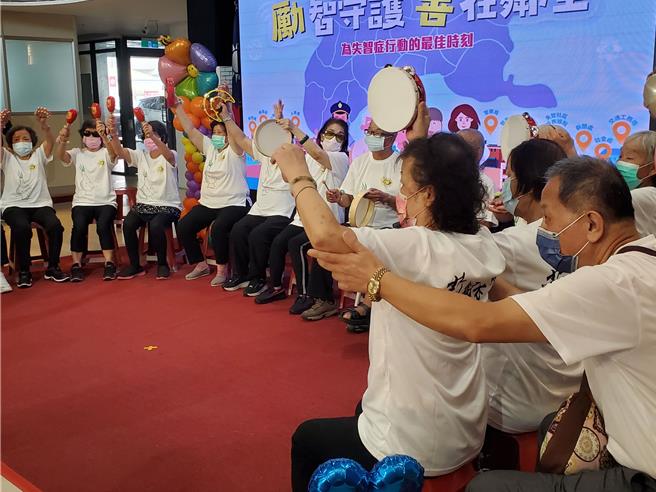 一名長者雖然坐輪椅也要參與成果發表，她的家人幫她抬手助一臂之力。（周麗蘭攝）