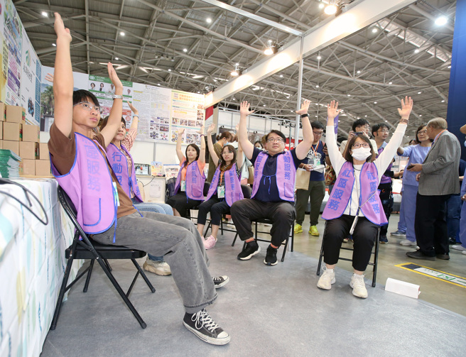 台北國際照顧博覽會12日登場，台灣社區醫院協會舉行「守護在地民眾健康 地區醫院揪『肝』心」記者招待會，並示範體操動作。（范揚光攝）