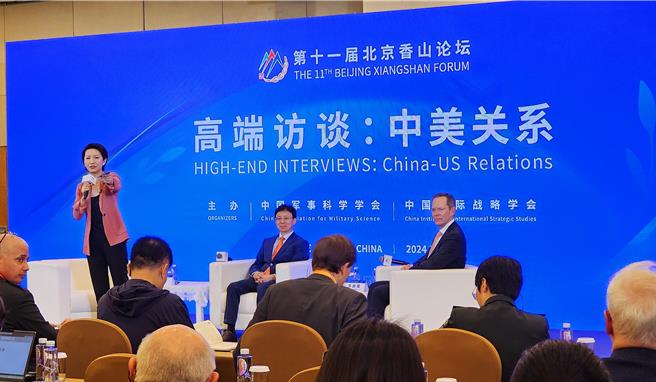 第11届北京香山论坛12至14日登场。今天上午高端访谈的中美关系环节，中美学者针对台湾问题犀利交锋。中方学者吴心伯（中）、美国学者华自强（右）。（蓝孝威摄）