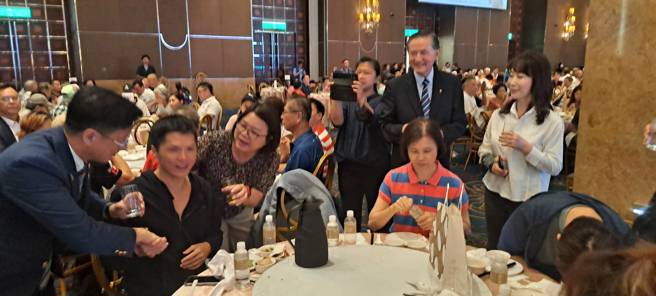 总监曾国峰逐桌致意出席的身障朋友。(国际扶轮社提供)