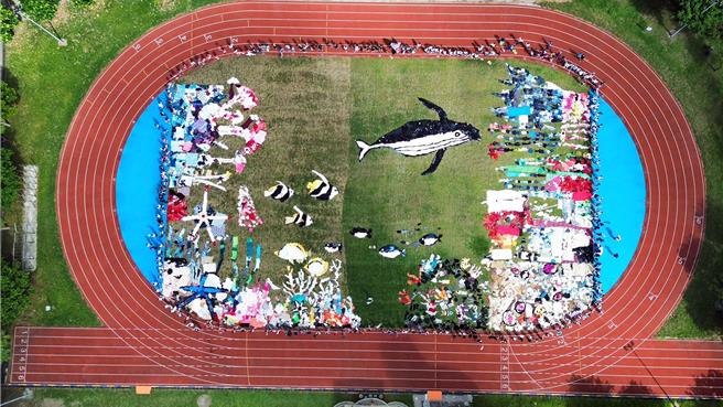 宜蘭縣冬山國中與藝術家吳成夫合作，14日用二手衣拼接，完成大型地景作品「鯨天動地」，吳成夫預計以1年時間將所有地景編輯成一部倡導減塑、永續理念的動畫。（冬山國中提供）