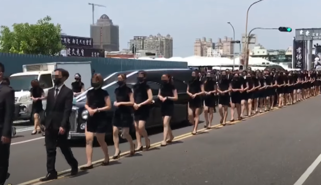 屏东角头「鸭头」陈昫豪告别式会场外，来了一整排穿着黑旗袍的长腿礼生。（图／翻摄自中天电视）