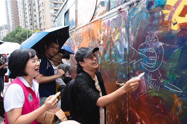 活动中，苏巧慧也和知名儿童绘本作家「赖马」一起亲自体验手绘巴士与在柏油路上涂鸦的乐趣，苏巧慧笑称，在专业的绘本作家旁边画画，根本是在「班门弄斧」。（立法委员苏巧慧服务处提供）