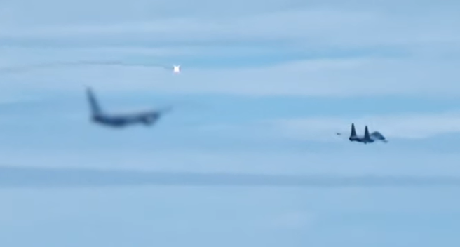 大陸央視近日上傳一段共軍戰機動用熱焰彈驅逐「不明外機」的影片，詳細記錄殲-16戰機（右）與外機（左）交手的過程。（圖 / 擷取自央視軍事YouTube）
