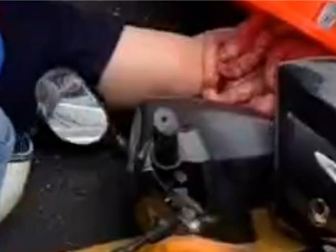 网友拍下机车骑士遭机车与联结货车压住画面，乍看之下怵目惊心。（翻摄社会事新闻影音／罗琦文屏东传真）