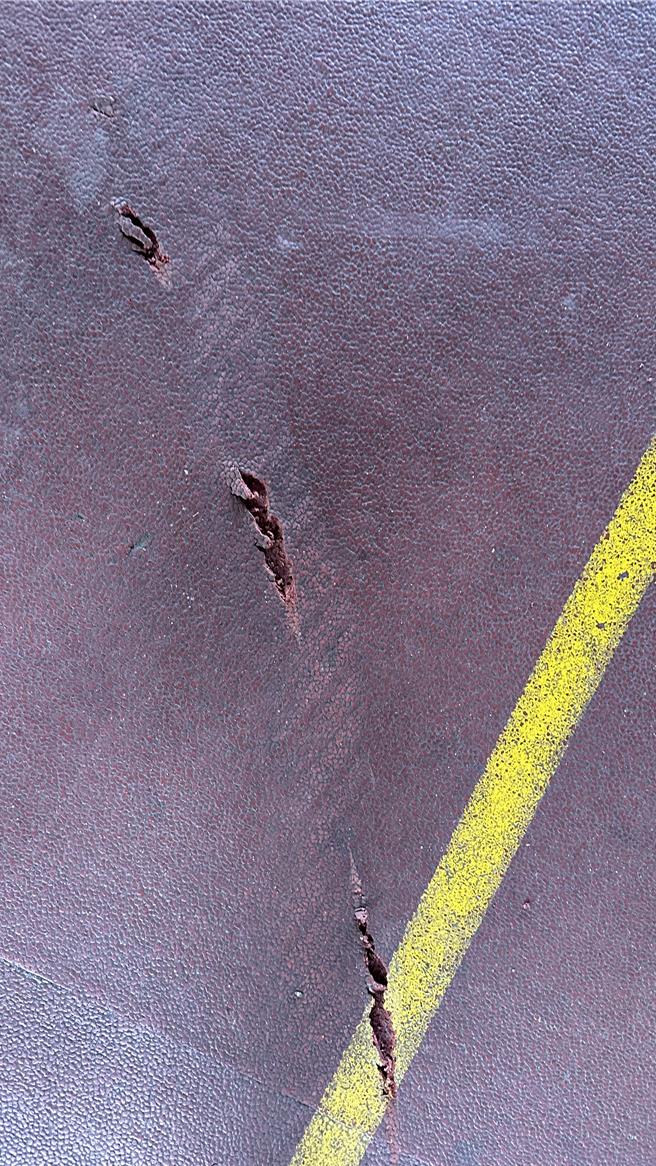 球場PU鋪面出現一道道刮痕、裂縫，還有疑似機車輪胎痕跡，推估遭闖入的機車中柱刮破。（民眾提供／楊靜茹南投傳真）