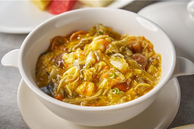 江南春的「蟹黄干贝盅」以红蟳蟹黄及南瓜泥混合成金黄浓郁的酱汁，加入以老母鸡汤熬煮的蟹腿肉、干贝和多样蔬菜，层次丰富。（图／台北福华大饭店）