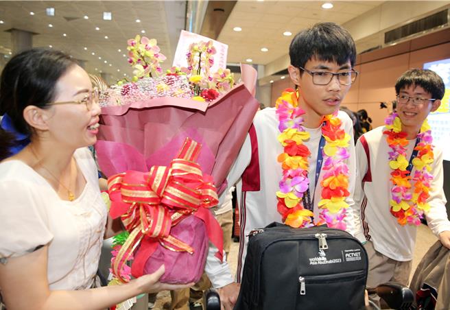 17日下午，代表團搭機抵達桃園機場，獲得金牌的「冷凍空調」職類國手陳思源（中）的親友前來接機獻花。（陳麒全攝）