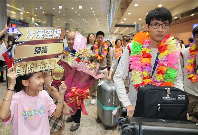 17日下午，代表團搭機抵達桃園機場，獲得金牌的「冷凍空調」職類國手陳思源（右）的親友前來接機獻花。（陳麒全攝）