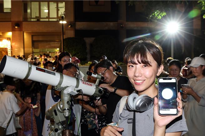 台北市立天文馆17日中秋夜举办赏月特别活动，除提供专业天文望远镜供民眾赏月，现场也设有手机拍摄专区，指导民眾如何用手机透过天文望远镜拍下月亮细节。民眾开心地展示她手机里的月亮照片。（邓博仁摄）