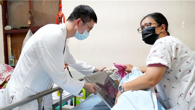 急诊医学部主治医师何郁玠(左)与居家护理所护理师林育如透过可携式X光机，帮阿嬷完成拍摄。(奇美医院提供／曹婷婷台南传真)