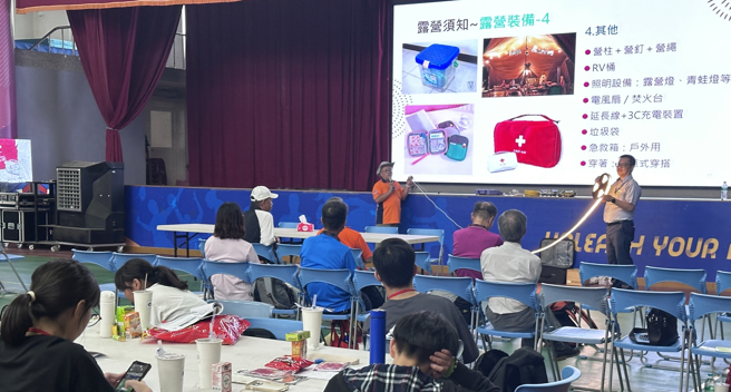 中華民國露營協會副秘書長簡明昌(前左)向學生展示露營用LED燈條。(照片/新北市政府教育局提供)